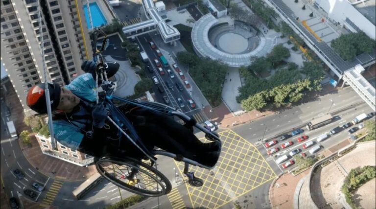 Un parapléjico logra escalar un rascacielos en Hong Kong en silla de ruedas