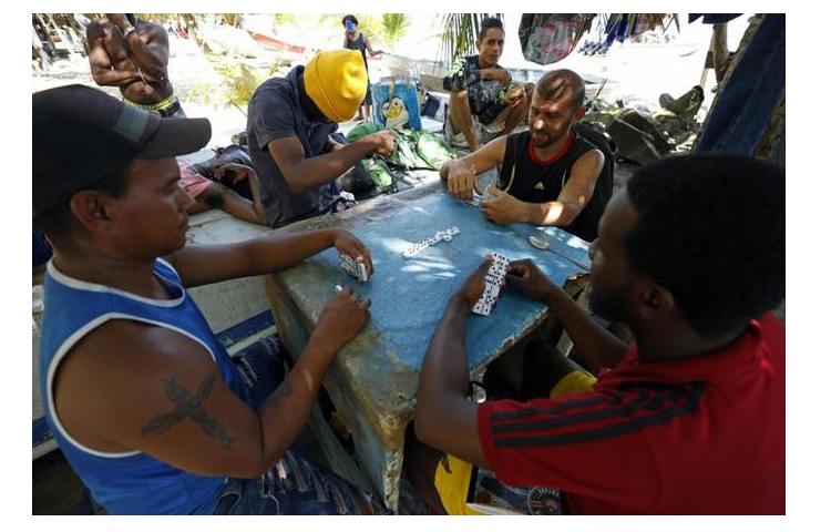 Migrantes matan el tiempo jugando mientras  esperan su paso hacia «el sueño americano» en la frontera entre Colombia y Panamá