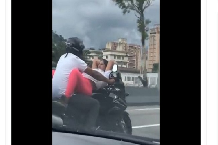 Amor imprudente: Pareja se besa mientras viaja en moto por una autopista de Caracas (+Video)